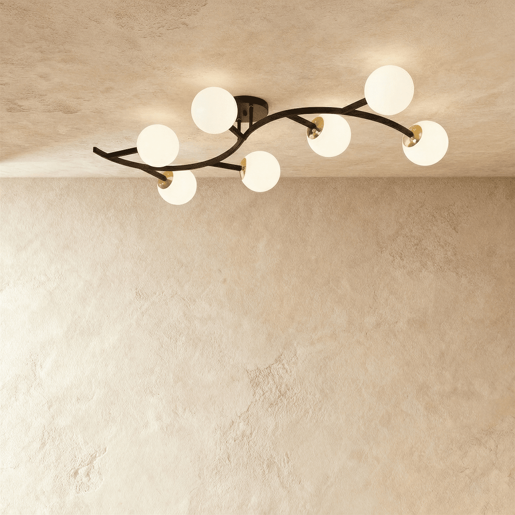 Clérachic seven-globe ceiling light with a sweeping black arm, brass joints and opal white glass globes, lit.