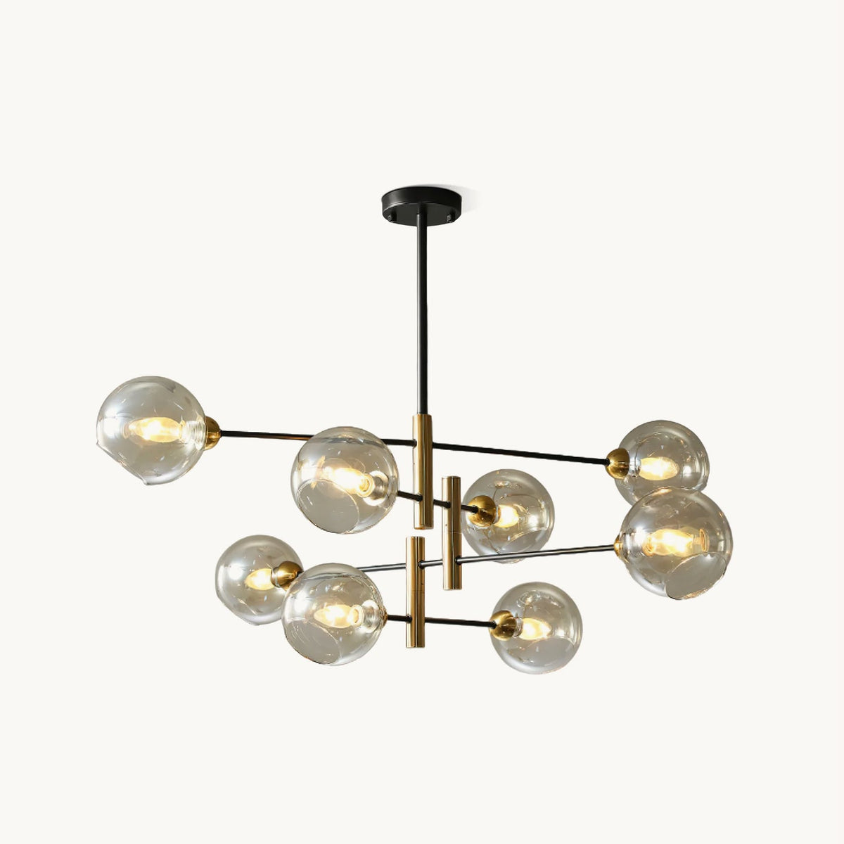 Eight-head Clérachic chandelier with amber glass globes on black arms and brass-toned stems, hung from a black rod on a white backdrop.