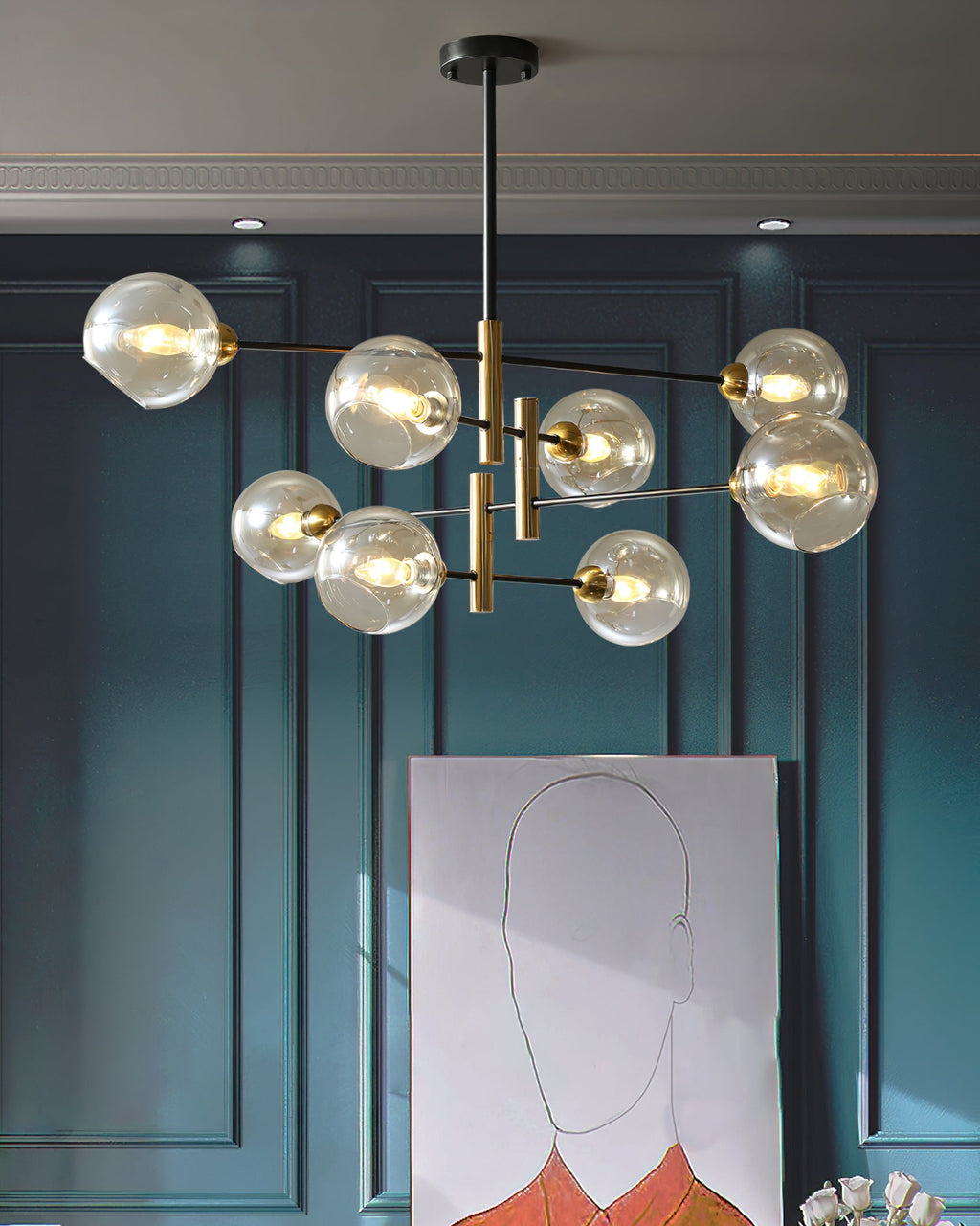 Clérachic chandelier with amber globes glowing in a teal panelled room, above a large line drawing leaning against the wall.