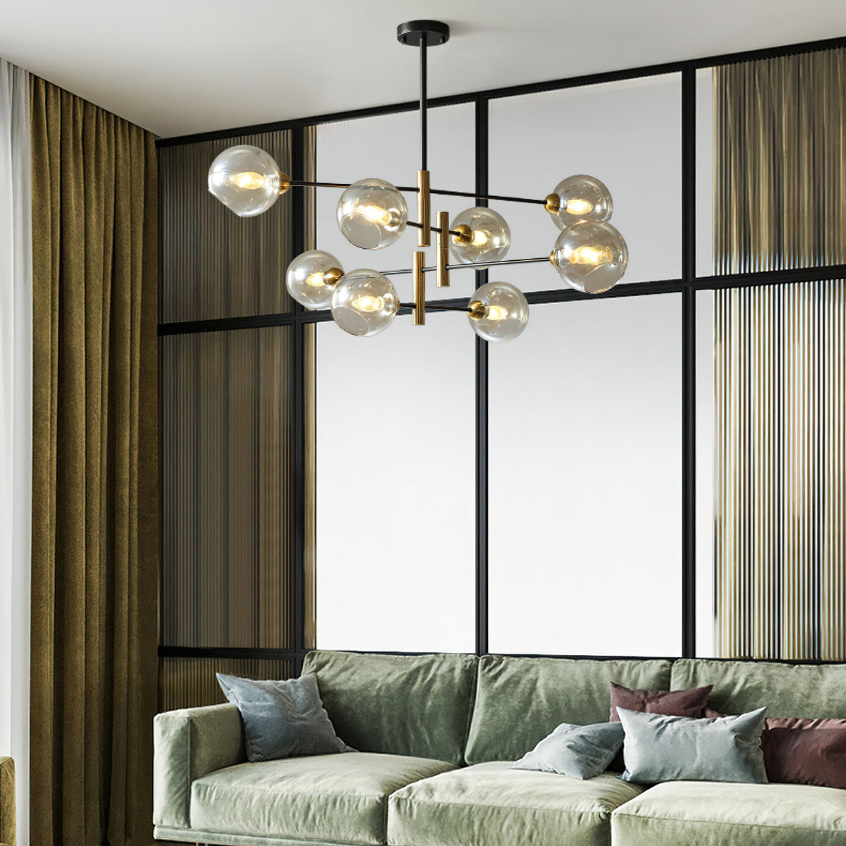 Clérachic chandelier with amber globes in a room with a black-framed glass partition, olive curtains and a sage green sofa.