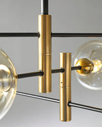 Close view of the brass stems and black arms where the globes of this Clérachic chandelier meet.
