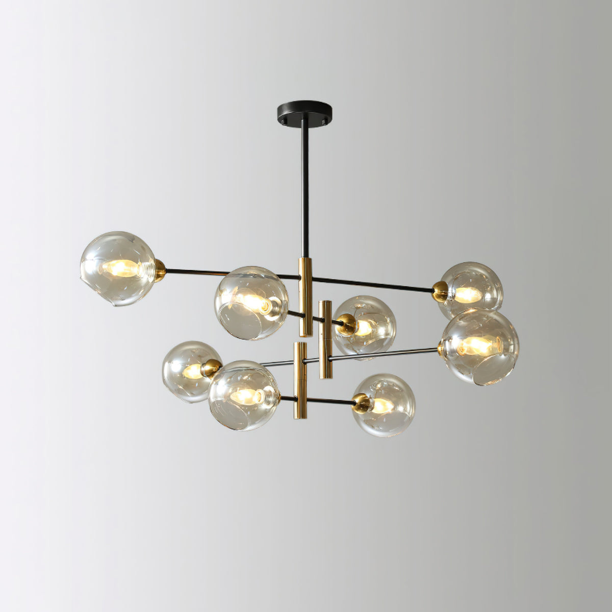 Eight-head Clérachic chandelier with amber globes, seen from a slight angle against a pale grey backdrop.