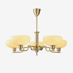 Clérachic five-head copper chandelier with flattened white glass globes, studio side view on a grey backdrop.