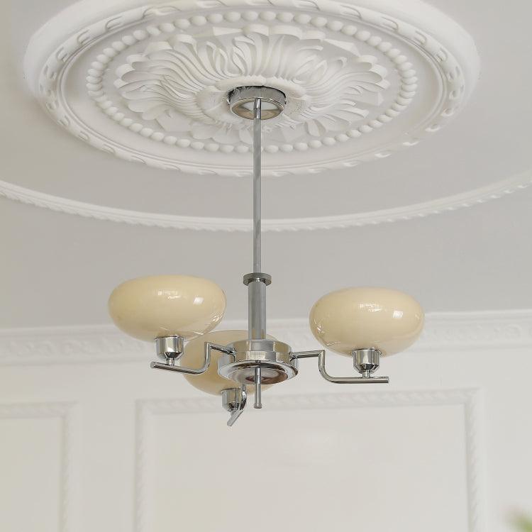 The Clérachic three-head chrome chandelier in cream glass, viewed from below in a panelled room.