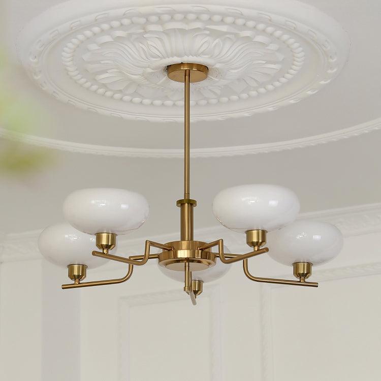 The Clérachic five-head copper chandelier seen from below, white glass globes spread across a wide span.