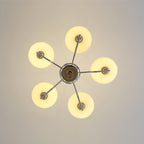 Clérachic five-head chrome chandelier from directly below, five cream globes glowing in a star pattern.