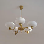 Clérachic five-head copper chandelier with one globe on the hub and four on stepped arms, white ceiling.