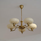 Clérachic five-head copper chandelier unlit, five white globes on stepped arms against a plain white ceiling.