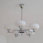 Clérachic five-head chrome chandelier unlit, one globe on the hub and four on bent chrome arms.