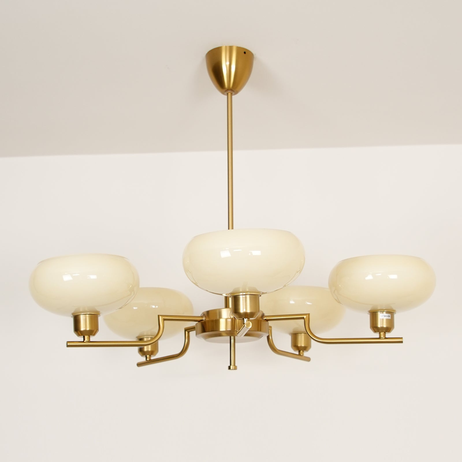 Clérachic five-head copper chandelier with cream bowl-like globes, one centred and four on radiating arms.