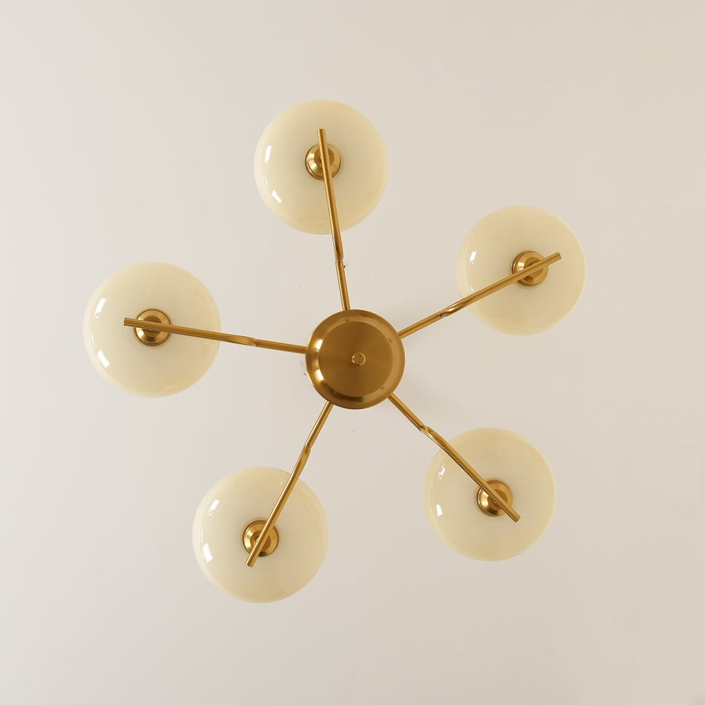 Clérachic five-head copper chandelier from directly below, five unlit white globes in a star pattern.