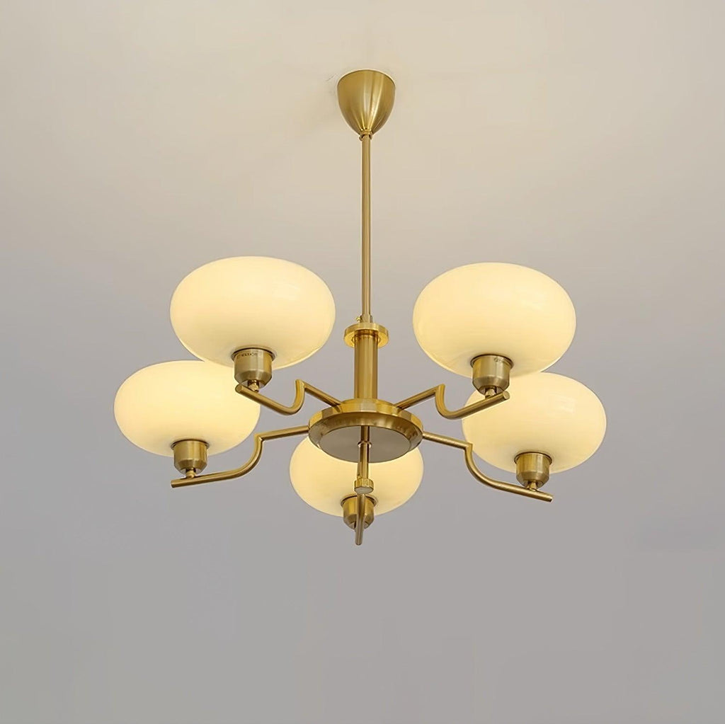Clérachic five-head copper chandelier lit in studio, five glowing globes in a star on a pale grey wall.