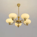 Clérachic five-head copper chandelier lit in studio, five glowing globes in a star on a pale grey wall.
