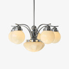 Clérachic glass globe chandelier in chrome, six cream globes plus a central bowl, softly glowing on a grey studio backdrop.