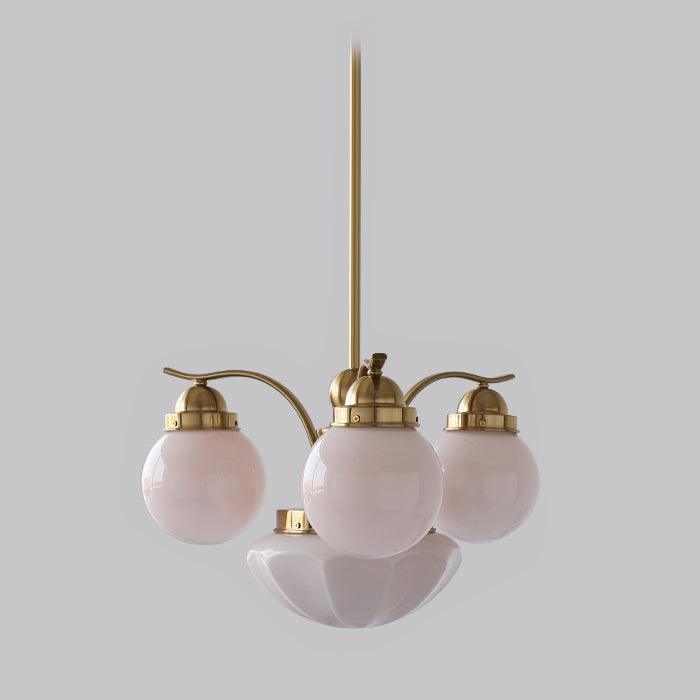 Clérachic copper-plated 4-light glass globe chandelier with blush-pink globes and a fluted bowl on a grey ground.