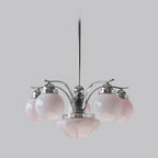 A Clérachic chrome 6-light glass globe chandelier hangs unlit, pale pink globes circling the lower bowl.