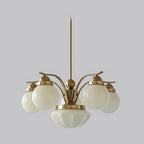 A Clérachic 6-light copper-plated glass globe chandelier fans white globes from the hub over a dining table.
