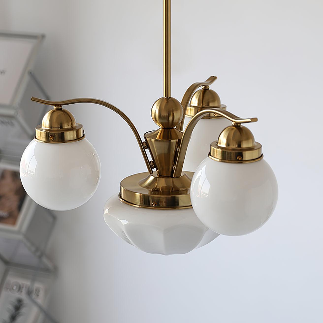 Clérachic copper-plated 4-light glass globe chandelier in a white-walled room, a magazine rack soft in the background.