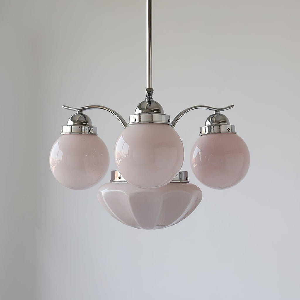 Clérachic chrome 4-light glass globe chandelier with pale pink globes and wavy decorative caps on the fittings.