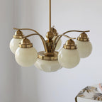 Clérachic 6-light copper-plated glass globe chandelier close above a table dressed with a botanical runner.