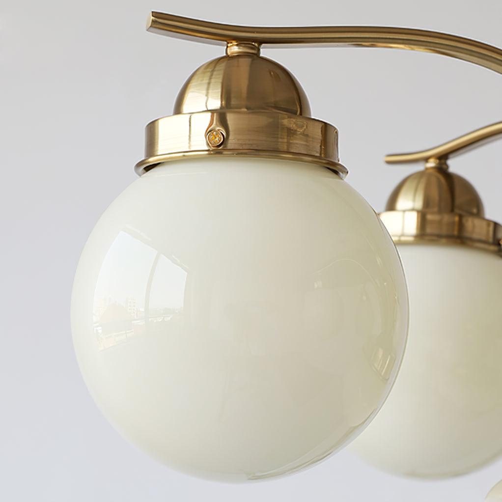 Close-up of a Clérachic copper-plated glass globe chandelier shade, a cream globe under a screw-fixed metal cap.