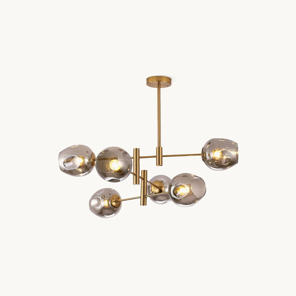 Gold-finish branching chandelier with smoky grey glass globes on slim arms and a long rod, from Clérachic, on a plain white backdrop.