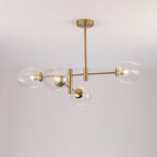 Four clear glass globes on a gold-finish chandelier seen from below against a pale ceiling, a Clérachic ceiling-mounted design.