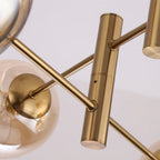 Close view of the brass tube joints and slim arms where the globes attach on this Clérachic chandelier.