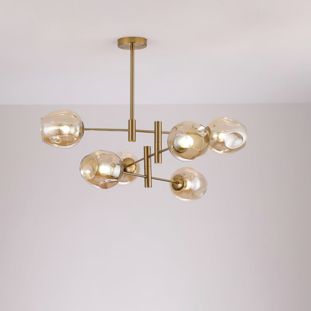 Amber-toned glass globes lit on a smaller gold-finish Clérachic chandelier hung from a slim rod, against a soft grey wall.