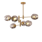 Smoky grey glass globes lit on a gold-finish Clérachic chandelier, shown cut out on a plain white background.