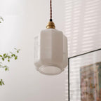 Clérachic glass globe pendant light glowing softly near a sheer curtain and framed artwork in a sunlit room.