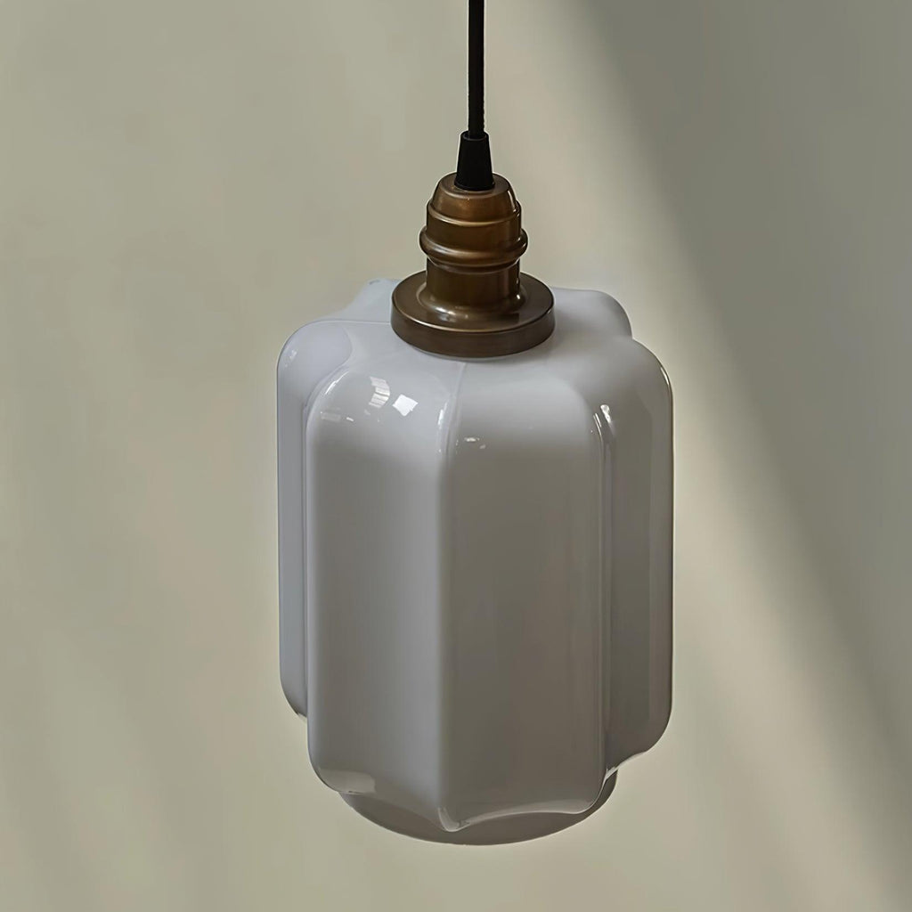 Close-up product shot of the Clérachic glass globe pendant light's faceted opal glass shade and brass cap.