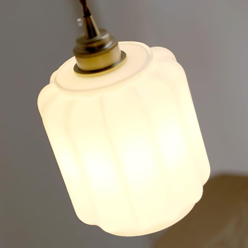 Clérachic glass globe pendant light photographed at a dramatic upward angle while lit, brass fitting glowing warm.