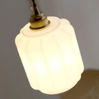 Clérachic glass globe pendant light photographed at a dramatic upward angle while lit, brass fitting glowing warm.