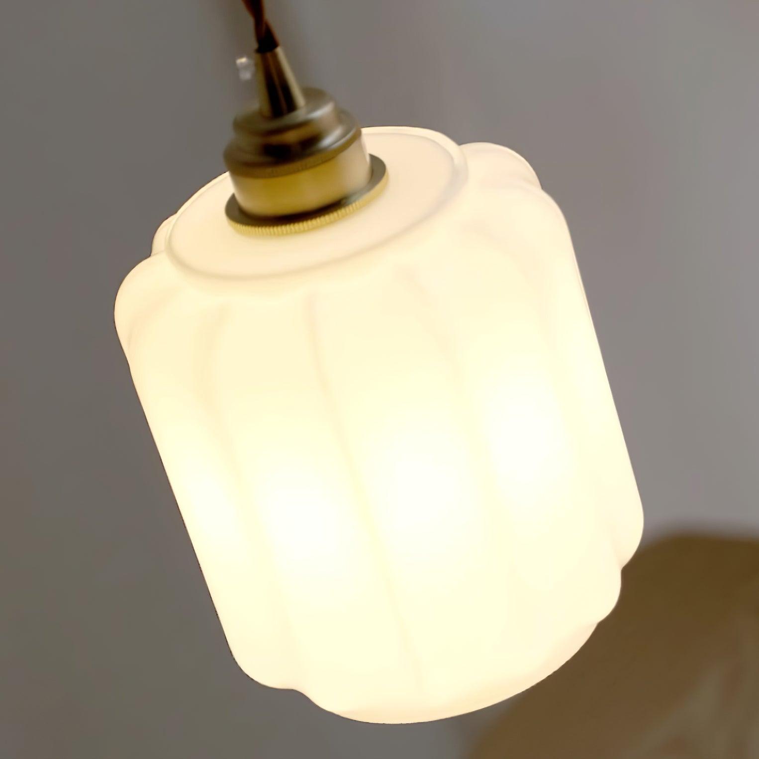 Clérachic glass globe pendant light photographed at a dramatic upward angle while lit, brass fitting glowing warm.
