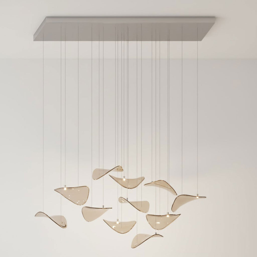 Long rectangular canopy with a sparse group of amber glass leaves on cables, in a pale room, from Clérachic.