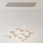 Long rectangular canopy with a sparse group of amber glass leaves on cables, in a pale room, from Clérachic.