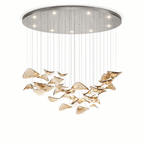 Chrome canopy with small downlights above a wide hanging group of amber glass leaves, from this Clérachic pendant, on white.