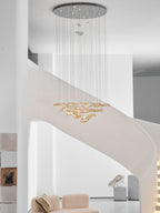 Clérachic amber leaf pendant with a round chrome canopy high above, hung in a white stairwell beside a stone sculpture.