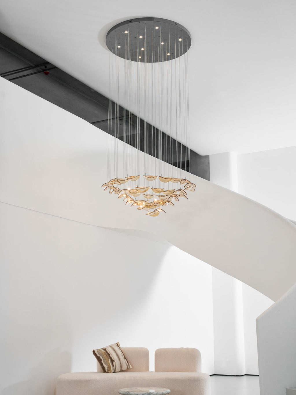 Dark round canopy with bright downlights above tiered rings of amber glass leaves from this Clérachic pendant.
