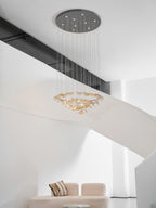 Dark round canopy with bright downlights above tiered rings of amber glass leaves from this Clérachic pendant.