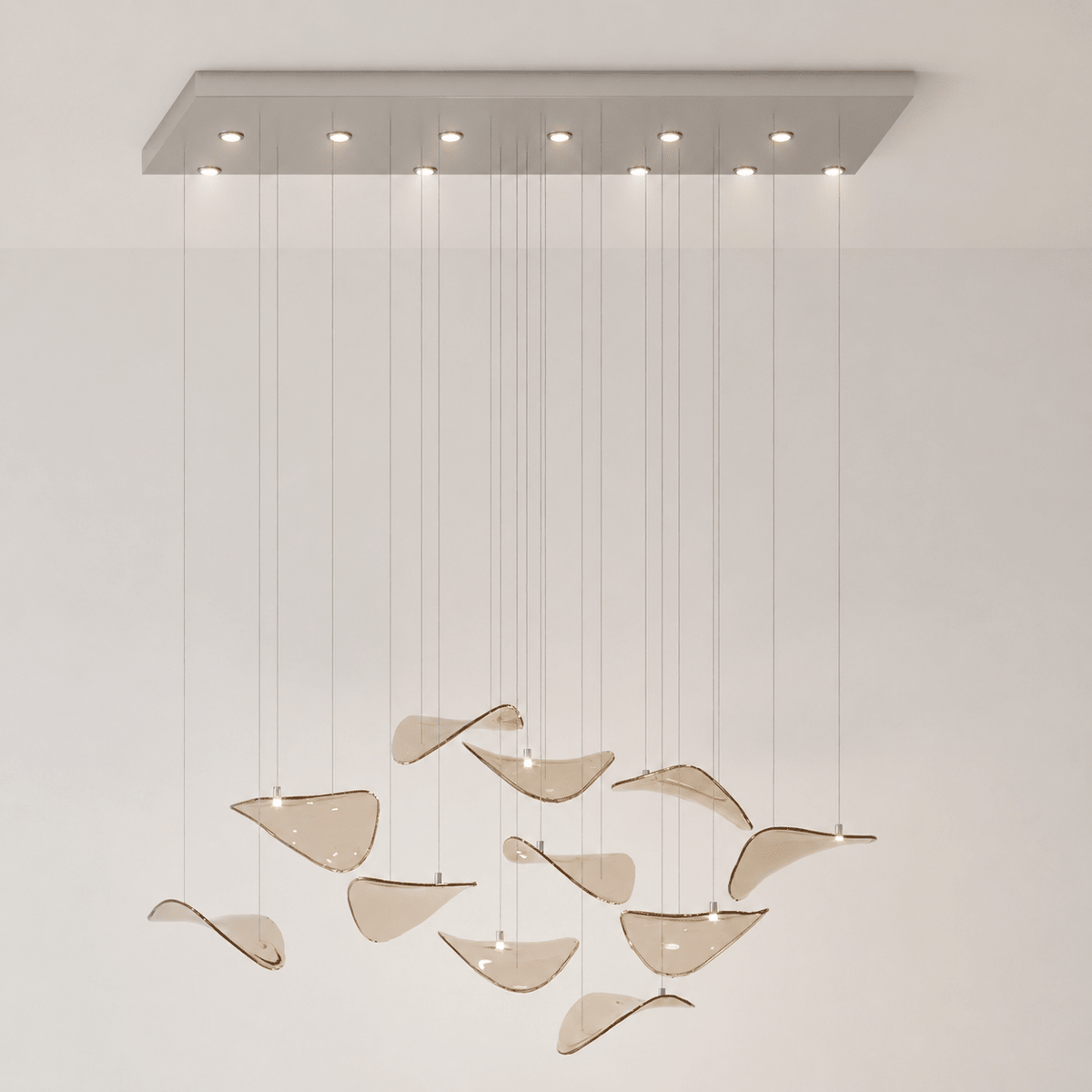 Rectangular canopy with downlights above a sparse group of amber glass leaves hung low, from this Clérachic pendant.
