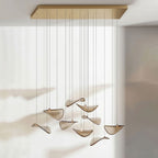 Long gold canopy with a loose group of amber glass leaves hanging from fine cables, from this Clérachic pendant.