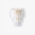 This Clérachic wall light on a plain white backdrop, layers of clear ribbed glass leaves rising to small brass tips.