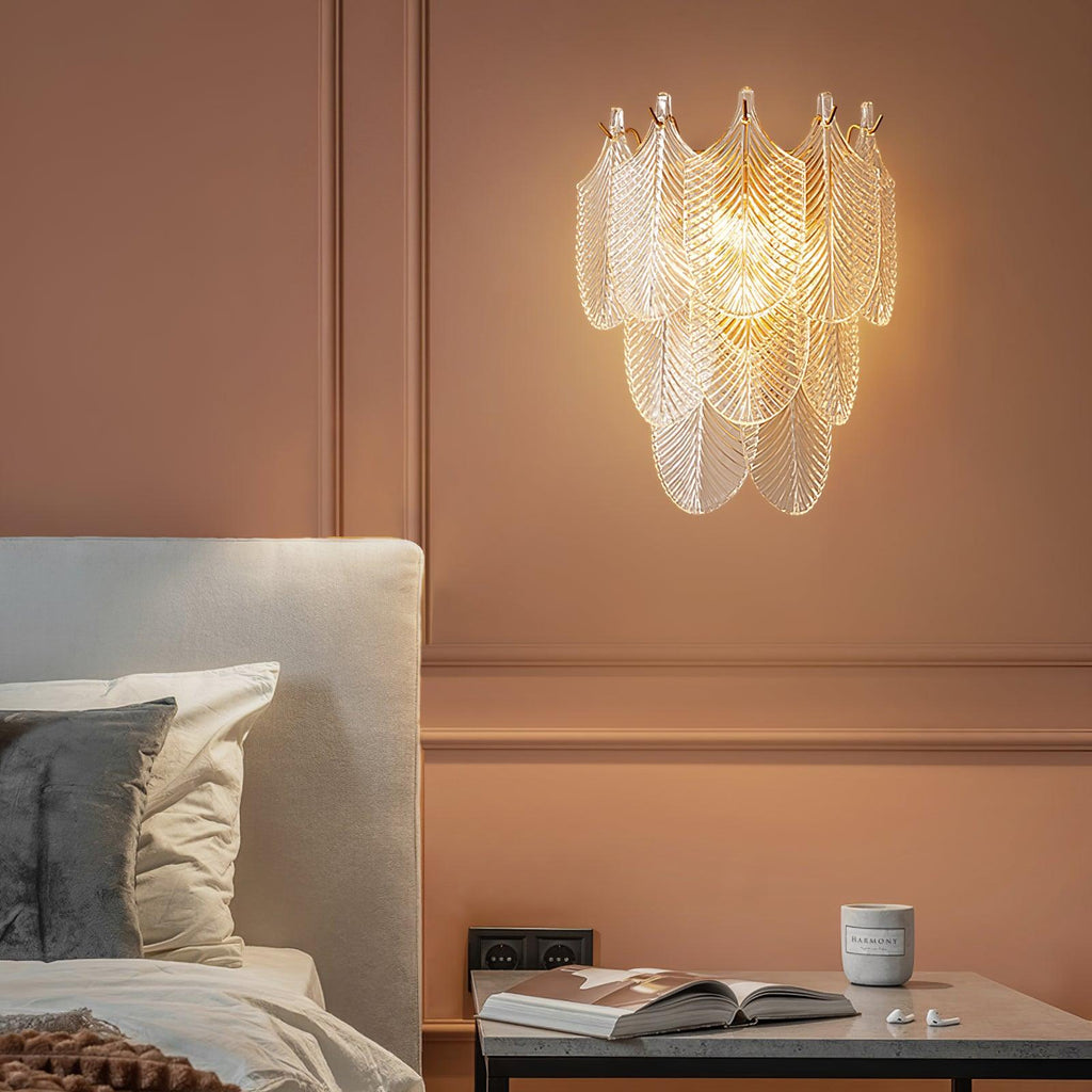 Lit Clérachic wall light on a terracotta panelled wall above a bedside table with an open book and a small cup.