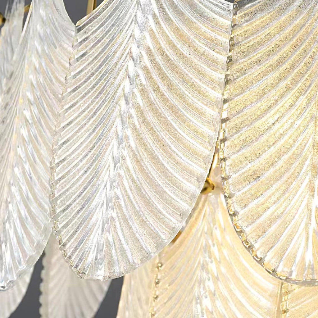 Close view of the finely textured glass surface on the leaves of this Clérachic wall light, with a gold glow behind.