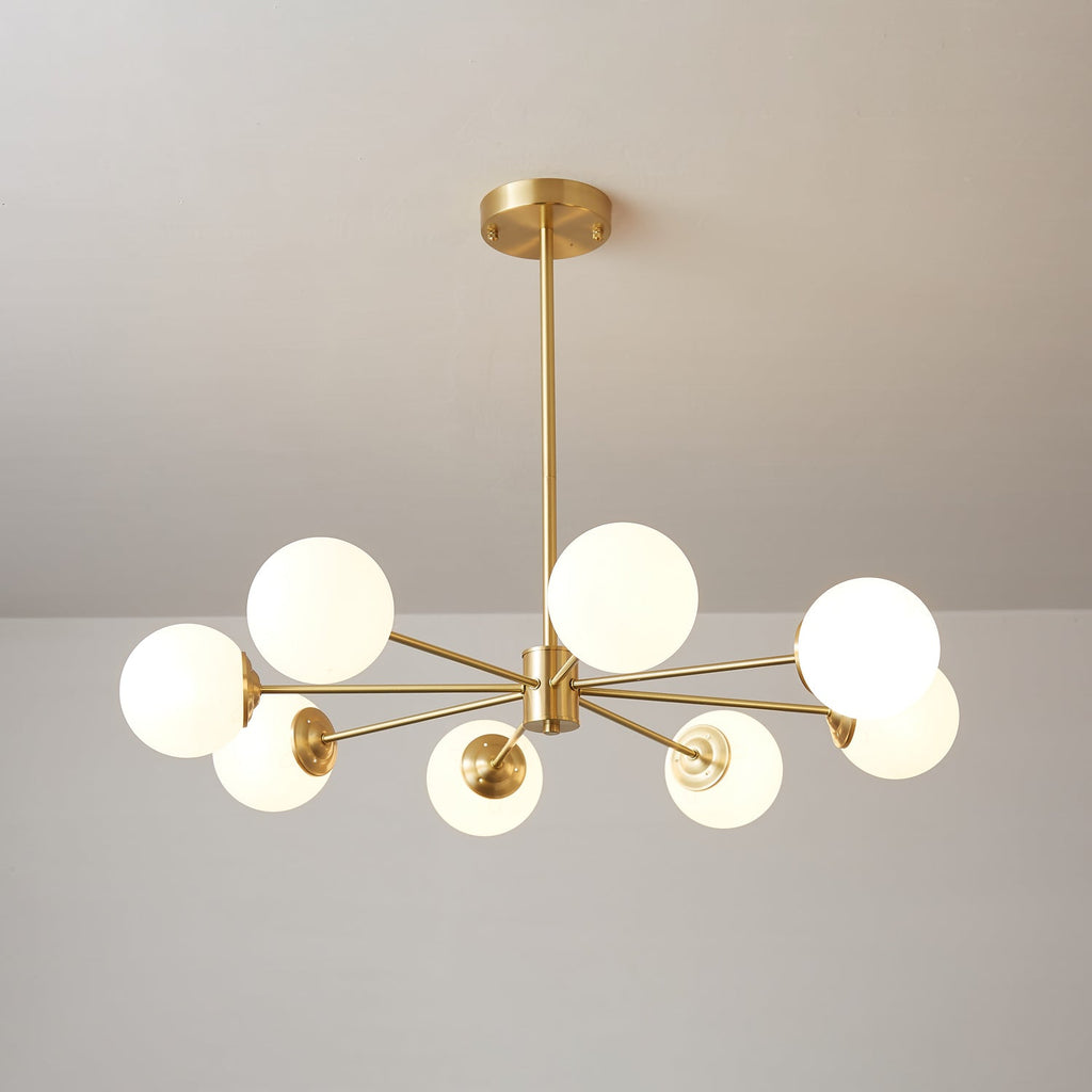 Wide, flat arrangement of lit glass orbs on a brass hub, this Clérachic chandelier hanging from a long drop rod.