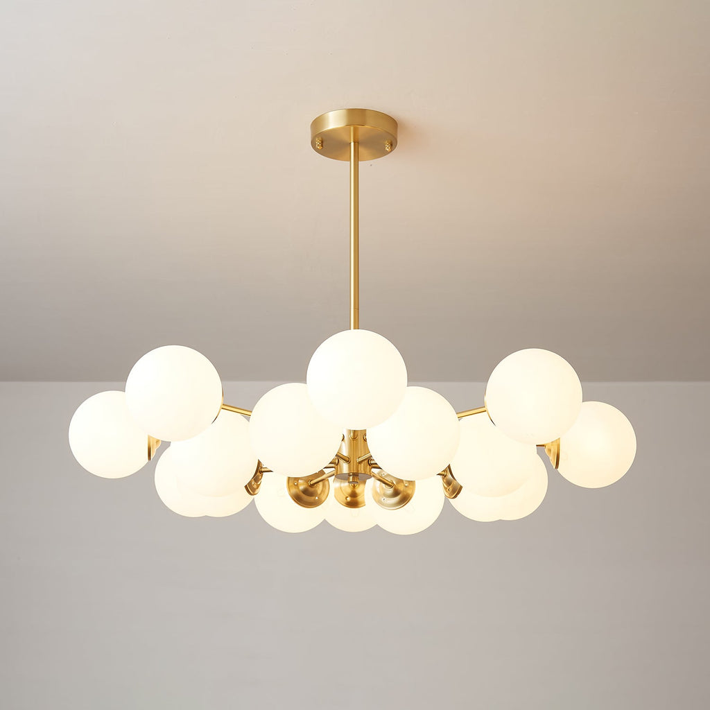 Dense Clérachic chandelier with many lit frosted orbs around a brass hub, seen from slightly below.