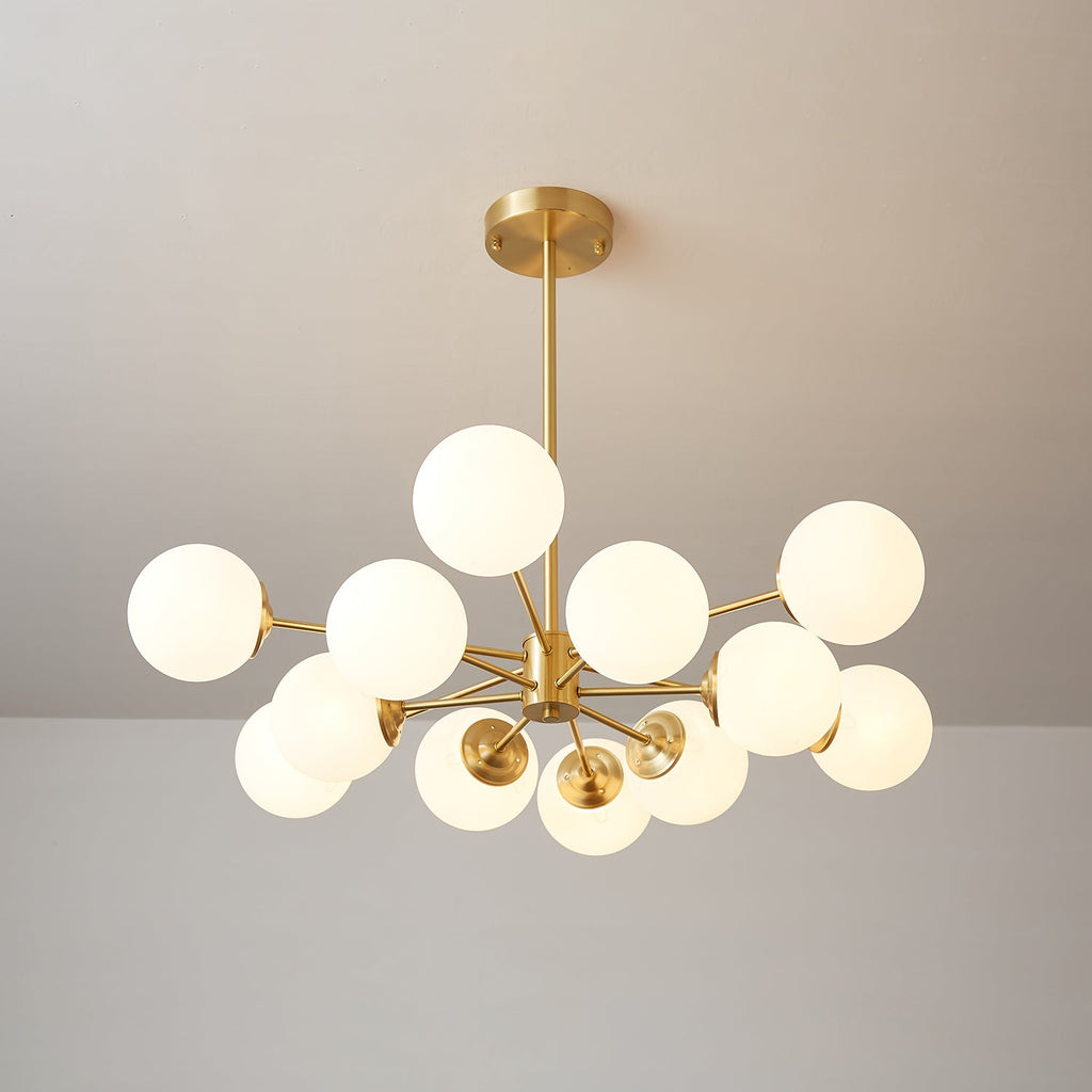 Clérachic chandelier with lit orbs on branching brass arms, one globe held high above the rest.