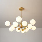 Clérachic chandelier with lit orbs on branching brass arms, one globe held high above the rest.
